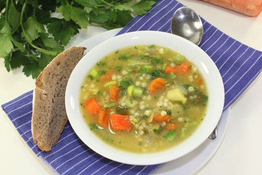 a bowl of colorful barley soup in front of white background