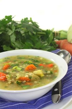 a bowl of colorful barley soup in front of white background