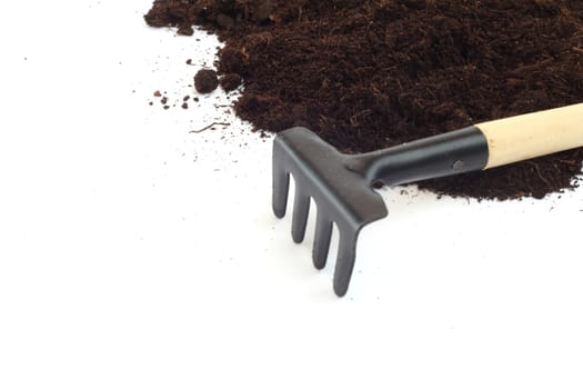 Rake and dirt isolated on white background, gardening concept