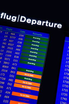 Airport departure board in terminal with flight information