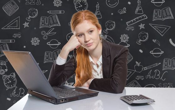 Young well dressed red haired Girl is sitting frustrated in front of the computer