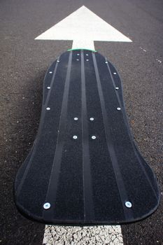 Vintage Style Longboard Black Skateboard on an Empty Asphalt Desert Road