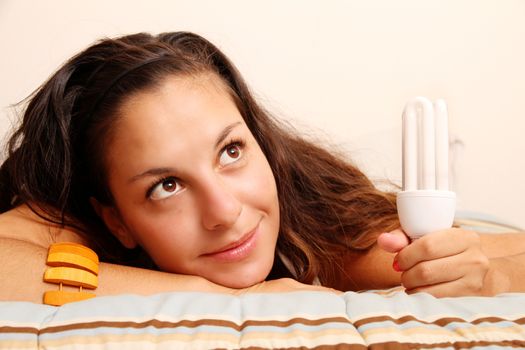 Young girl with a energy saver light bulb.