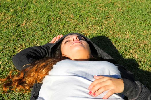 A young woman enjoying the sunlight in the Park.			
