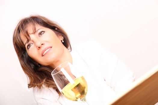 A beautiful mature woman with a glass of white wine.