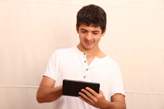 A young, latin man playing with a Tablet PC, face in focus
