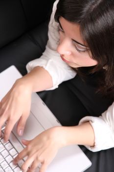 A young woman surfing on the Internet with a Laptop.  
