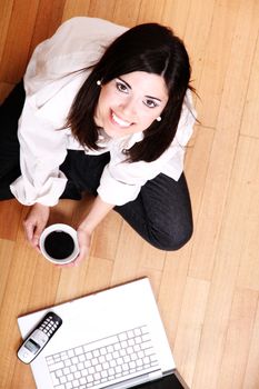 A young adult woman studying on the floor.