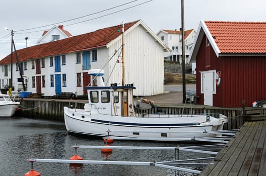 a lone fishing boat in its harbor a winter day