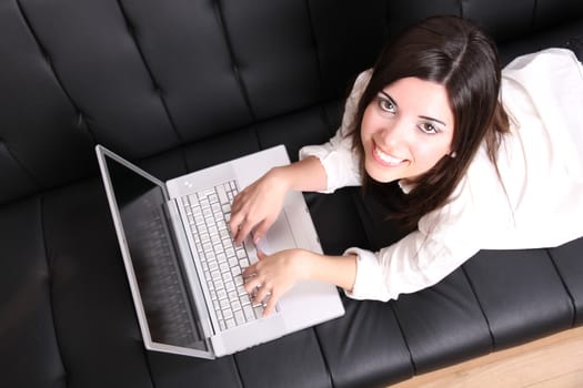 A young woman surfing on the Internet with a Laptop.  
