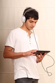A young, latin man playing with a Tablet PC