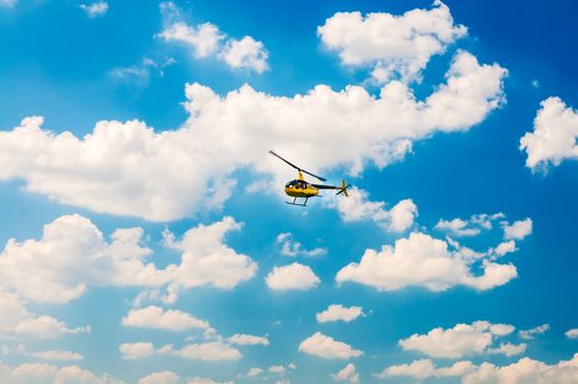 Yellow tourist Helicopter in the blue sky