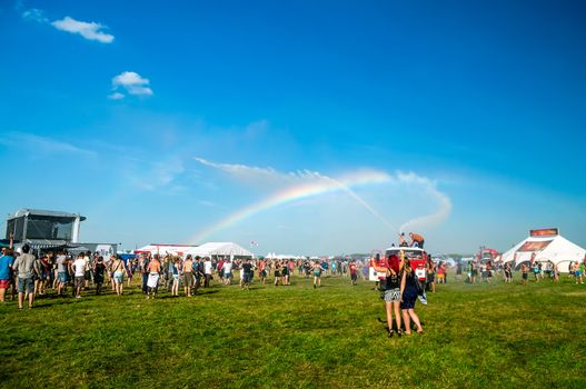 People enjoy the rainbow created from a fire truck water at Mighty Sounds festival 19th of July, 2013