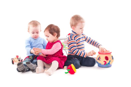 Three children play with toys isolated on white