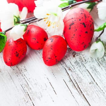 Red spotted eggs with apple flowers on the shabby wooden table