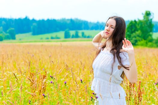 Russian beautiful woman in field with flowers