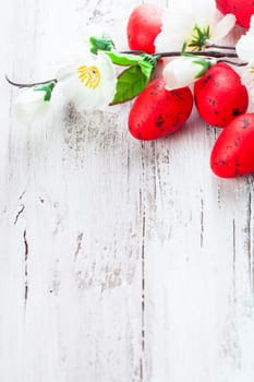 Red spotted eggs with apple flowers on the shabby wooden table