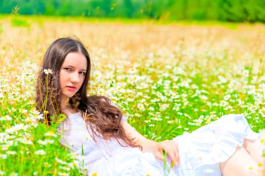 girl resting in summer field with flowers