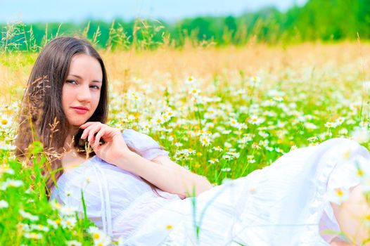 summer chamomile field and resting girl