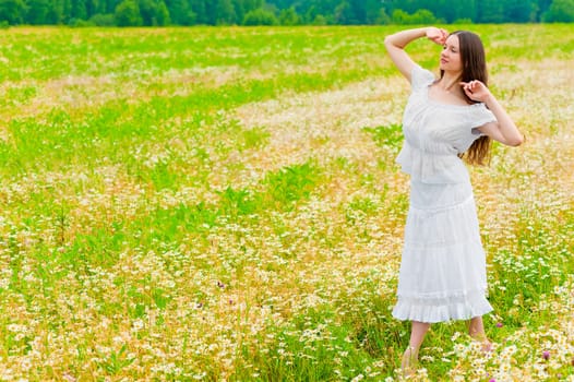 young brunette woman walking in a field with daisies