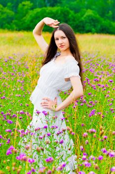 beautiful woman posing in a field with flowers