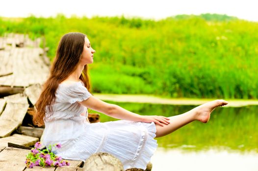 dancer sits on a bridge and pulling sock feet