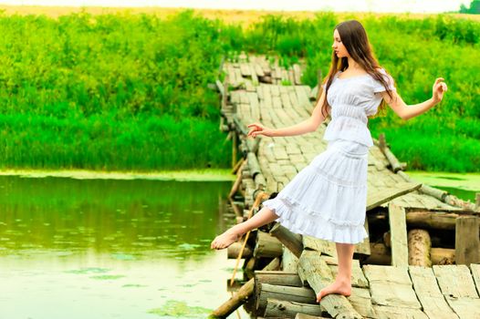 beautiful ballerina balancing on the bridge by the river