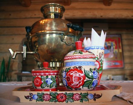 Russian tea drinking with samovar and traditional decorated wooden utensil in a traditional timber house