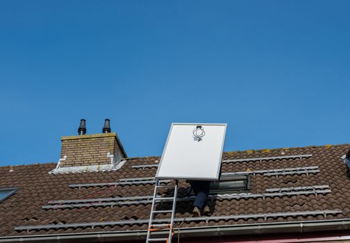 man climbing the ladder to the roof with solar panel