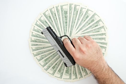 Man holding handgun over a stack of money