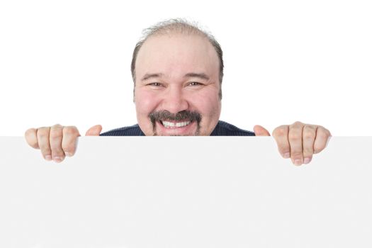 Businessman with a beaming cheesy grin holding a blank white sign suitable for advertising with just his head visible showing his approval of the product