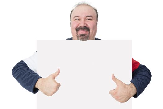 Happy smiling middle-aged man with a goatee holding a blank white board with copyspace for your text giving a thumbs up gesture of approval