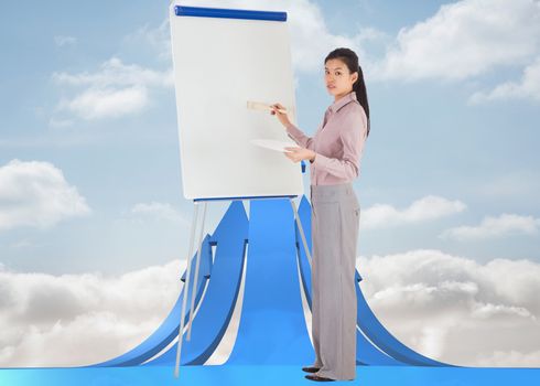 Businesswoman painting on an easel against blue abstract design in room