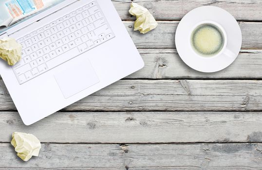 Laptop and coffee cup on old wooden boards. Computer technology concept