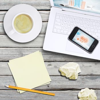 Laptop, smartphone and coffee cup on old wooden boards. Computer technology concept