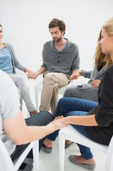 Group therapy in session sitting in a circle with therapist