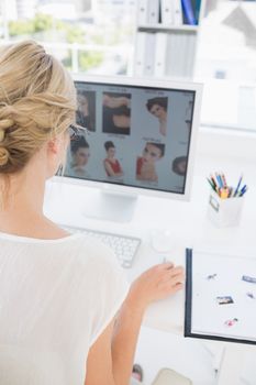 Rear view of a female photo editor working on computer in a bright office