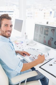 Side view portrait of a male photo editor working on computer in a bright office