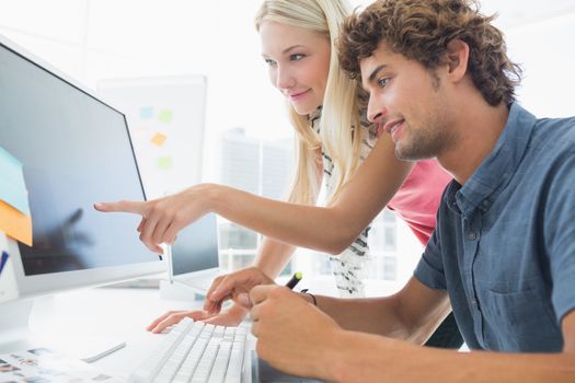 Casual business couple using computer in a bright office