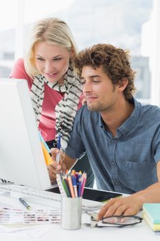 Casual business couple using computer in a bright office