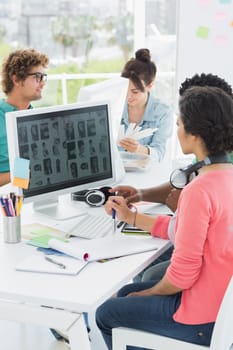 Group of casual artists working at desk in the creative office