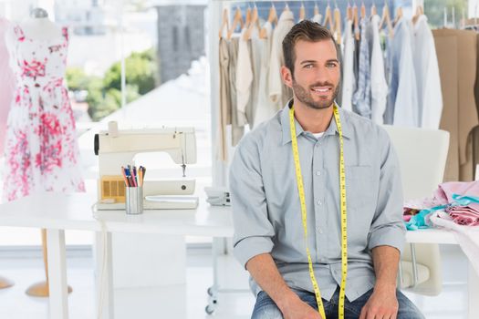 Portrait of a handsome male fashion designer sitting in the studio