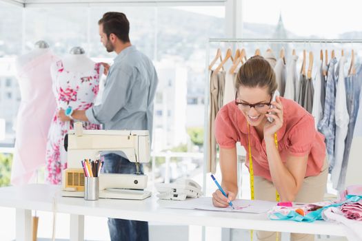 Male and female fashion designers at work in a bright studio