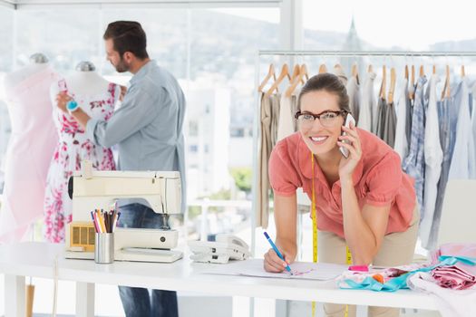 Male and female fashion designers at work in a bright studio