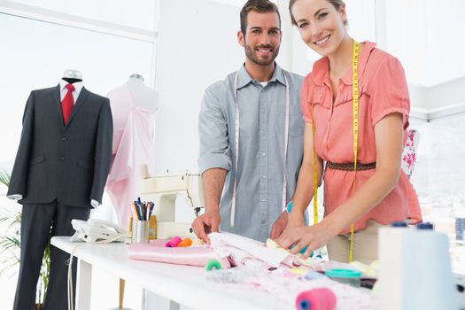 Male and female fashion designers at work in a bright studio