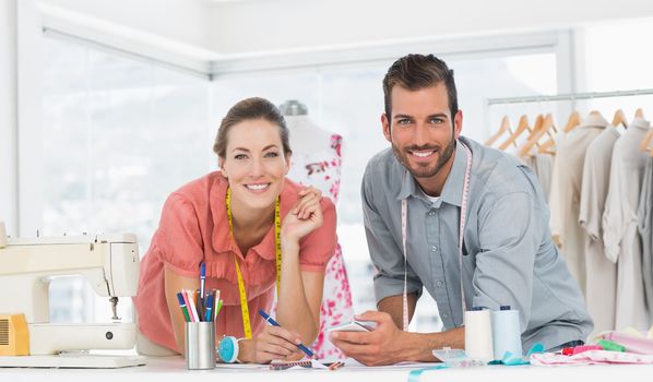 Male and female fashion designers at work in a bright studio