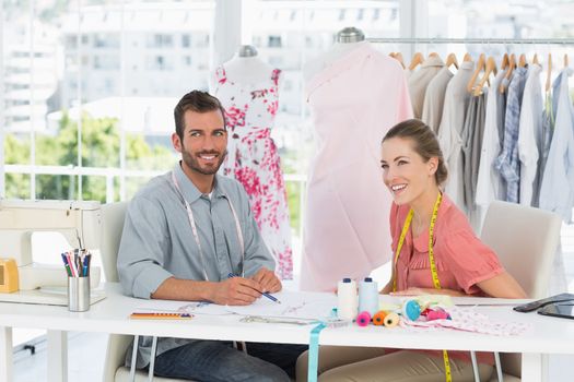 Male and female fashion designers at work in a bright studio