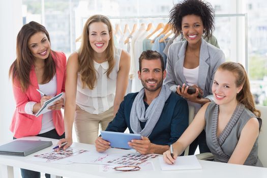 Group portrait of fashion designers discussing designs in a studio