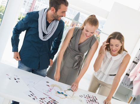 Three fashion designers discussing designs in a studio