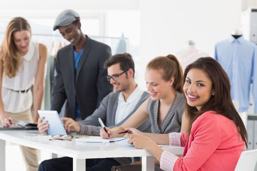 Group of fashion designers discussing designs in a studio